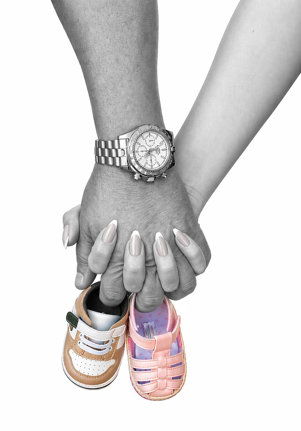 Elizabeth and Joshua holding hands above pink and tan baby shoes